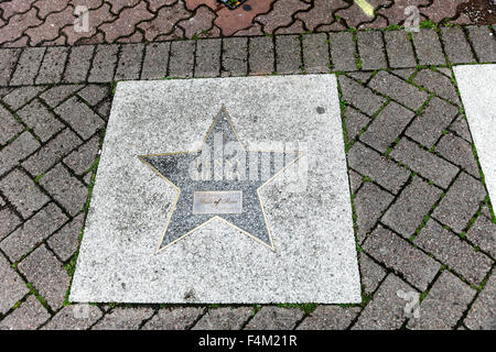 A star shaped plaque saying Lenny Henry in the pavement at Broad Street walk of stars Birmingham West Midlands England UK Stock Photo