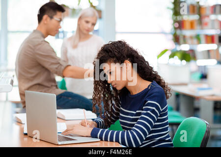 Portrait of female student studying at the table in university library Stock Photo