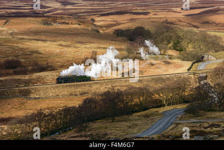 Vintage steam engine on its way from Goathland to Pickering passes through the North York Moors on a bright winter's day . Stock Photo