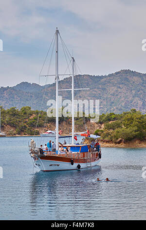 People taking a dip in the sea while the wooden Gulet boat is anchored for lunch on the 12 island tour out of Fethiye, Turkey. Stock Photo