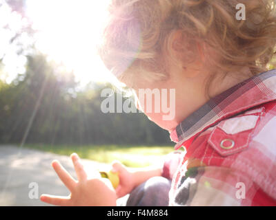 portrait of curly haired toddler boy in a checked shirt outdoors Stock Photo