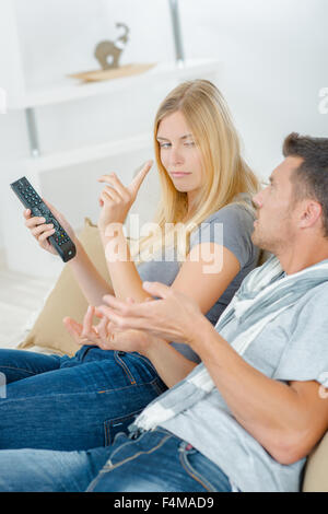 Couple arguing over remote control Stock Photo