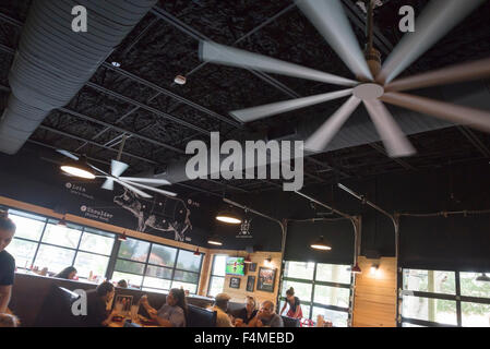 Brand new open-air interior of Sonny's BBQ restaurant sports humongous industrial strength and sized ceiling fans. Stock Photo