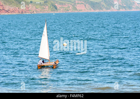Small catamaran sailing boat leaving Babbacombe Beach and entering Torbay on sunny September day in Torquay, Devon, England Stock Photo