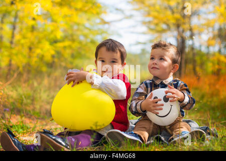 happy kids girl and boy with balloons on autumn day Stock Photo