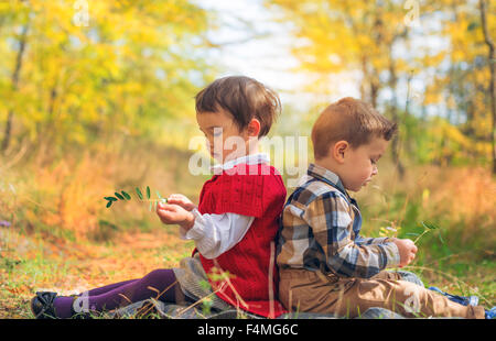 Two little kids playing he loves me or not Stock Photo