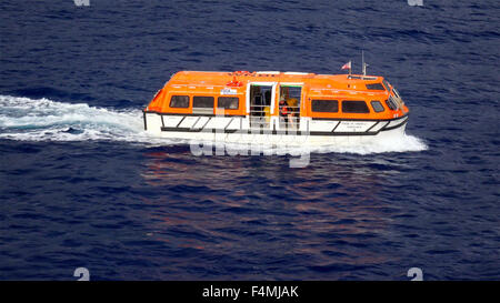 A cruise ship tender aka lifeboat returning to the ship full of tourists on Hawaii Stock Photo