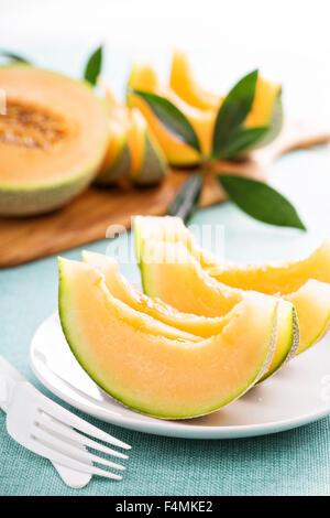 Ripe fresh cantaloupe slices on white plate Stock Photo