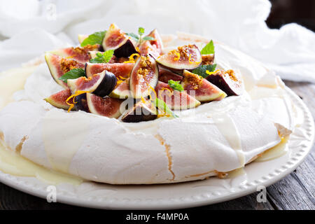 Pavlova cake with fresh figs, white chocolate, ricotta cream and orange zest Stock Photo