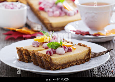 Pumpkin tart on gingerbread crust with candied cranberry Stock Photo