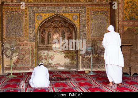 Men praying at the beautiful Wazir Khan Mosque in the old city center of Lahore, Pakistan Stock Photo