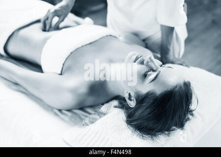 Woman enjoys massage of tummy at the health spa Stock Photo