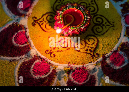 The Rangoli, an artwork made from colorpowder and an oil lamp to welcome the festival Diwali Stock Photo