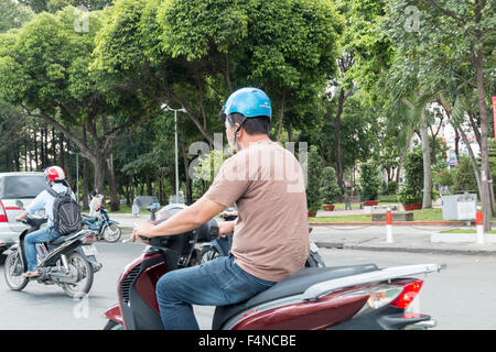 Vietnamese Motorcycle Rider Vietnamese man riding a motorcycle through the streets of Hoa Ho Trench ...