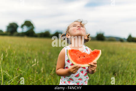 Little girl eating watermelon on a meadow Stock Photo