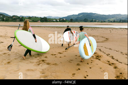 Spain, Asturias, Villaviciosa, three stand up paddler going to the water Stock Photo