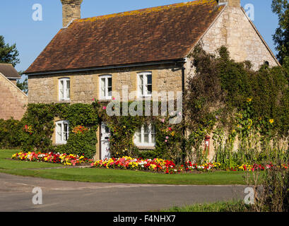 Country Cottage with climbing shrubs and colourful border plants at Newtown, Isle of Wight, England, UK Stock Photo