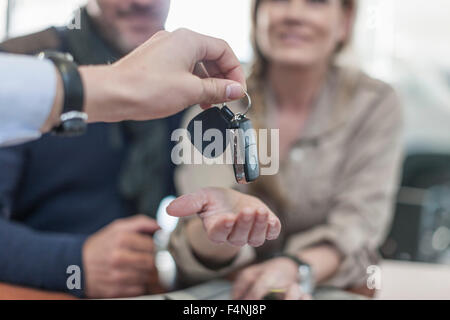 Car dealer giving key to client Stock Photo - Alamy