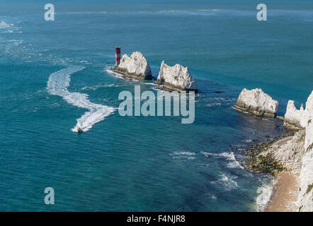 The Needles with speedboat speeding away leaving a line of foam in its wake, Isle of Wight, England, UK Stock Photo