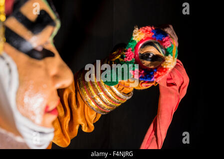 A Katakali artist is checking his make up of the character Shiva for the play Dhecheyagam by looking into a mirror Stock Photo