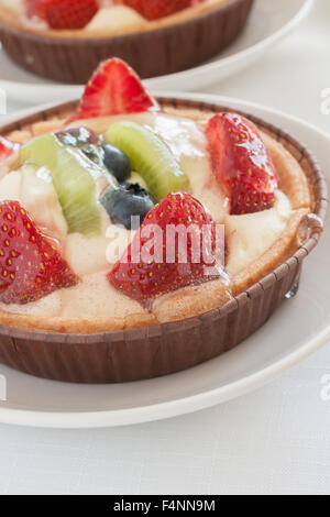 Fruit tarts made filled with creme patissiere strawberries kiwi fruit and blueberries Stock Photo
