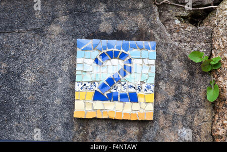 The number 2 or two in colourful blue and yellow mosaic tiles on a wall Stock Photo