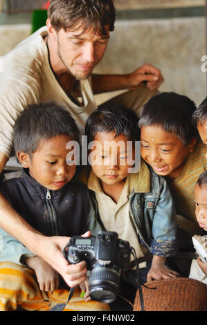 Nagaland, India - March 2012: Young photographer shows pictures on digital camera to small boys in village in Nagaland, remote r Stock Photo