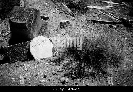 Scary cemetery showing an old grave in which the grave marker has been torn off done in a Black and White Film Noir grainy effec Stock Photo