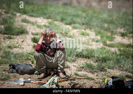 Old Lady resting on road side place Stock Photo