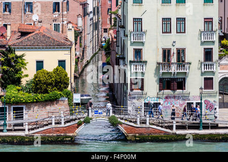 Narrow canal in Venice with graffiti on wall Stock Photo