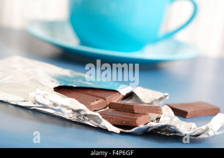 bar of dark chocolate on blue table top Stock Photo