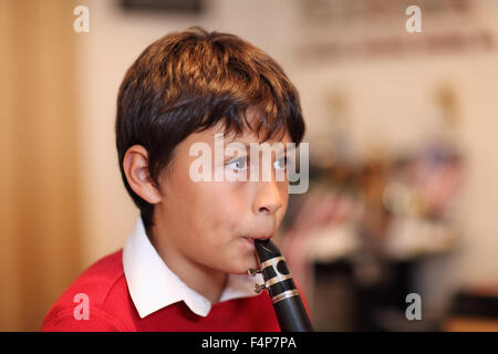 Young boy playing the clarinet - shallow depth of field - warm tones. Copy space Stock Photo