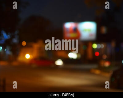 Abstract night scene with dim lights and headlights. Blur and defocused lights from the headlights of cars and traffic lights ca Stock Photo