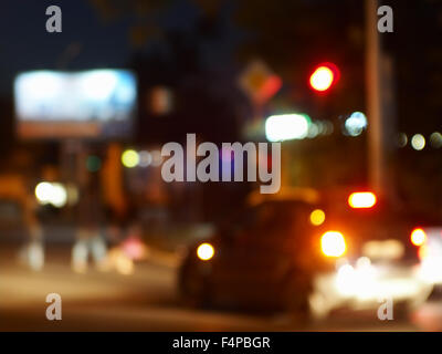Abstract night scene with dim lights and headlights. Blur and defocused lights from the headlights of cars and traffic lights ca Stock Photo