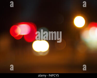 Abstract blurred image of round spots of bright multi-colored lights on night road closeup Stock Photo
