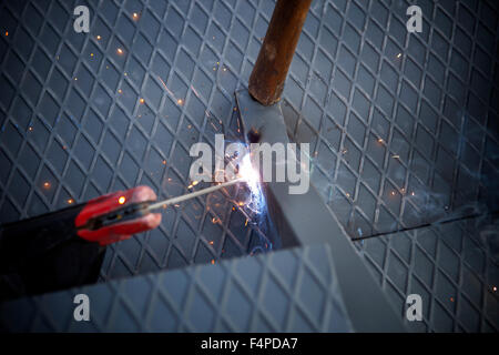 Two men working over iron platform with arc welding Stock Photo