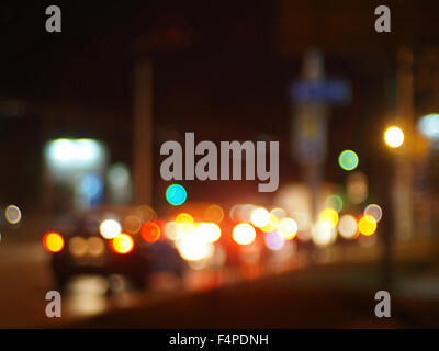 Defocused image of traffic on night city street. Trucks and cars with headlights was blurred for use as a background. Stock Photo