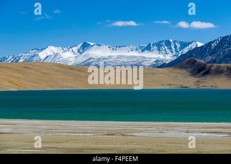 Barren landscape with a blue lake and snow capped mountains in Changtang area Stock Photo