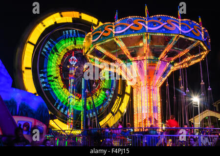 Swing Carousel and Ferris Wheel Rides on the midnight blue sky background Stock Photo