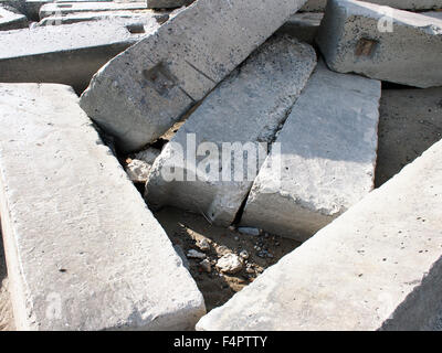 Large concrete building blocks closeup, piled up in a mess big heap on the sand. Stock Photo
