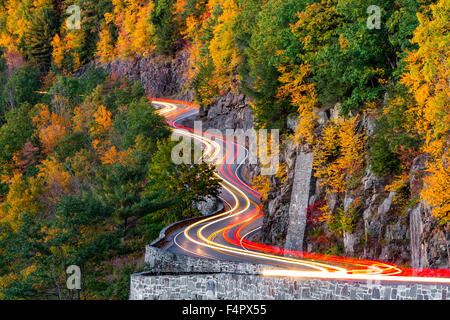 Traffic light trails on Hawk's Nest winding road (route 97) in Upstate New York, on an autumn evening. Stock Photo