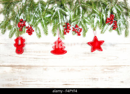 Christmas tree branches with red handmade toys decoration on bright wooden background. Winter holidays concept Stock Photo