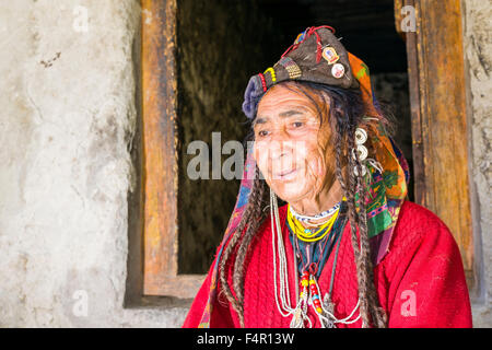 A woman of the Brokpa tribe, an arien race, in her traditional dress with a flower arrangement carried on the head Stock Photo