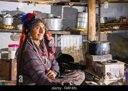 A woman of the Brokpa tribe, an arien race, in her traditional dress with a flower arrangement carried on the head Stock Photo