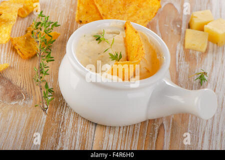 Cheese Sauce with Nachos on  wooden table. Selective focus Stock Photo