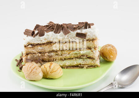 Chestnut cake slice on a green plate served with whole cooked chestnuts Stock Photo