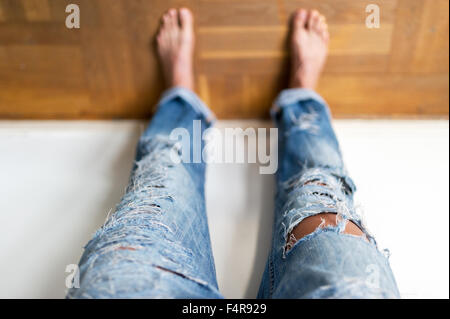 young girl is cutting her jeans (MR) Stock Photo
