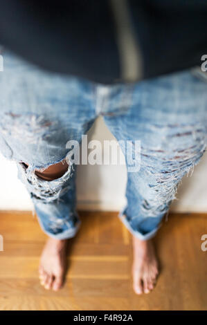 young girl is cutting her jeans (MR) Stock Photo