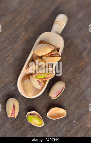 spoon of raw pistachio nuts on a old wooden background Stock Photo