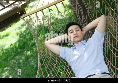 The young man is sleeping in a hammock Stock Photo